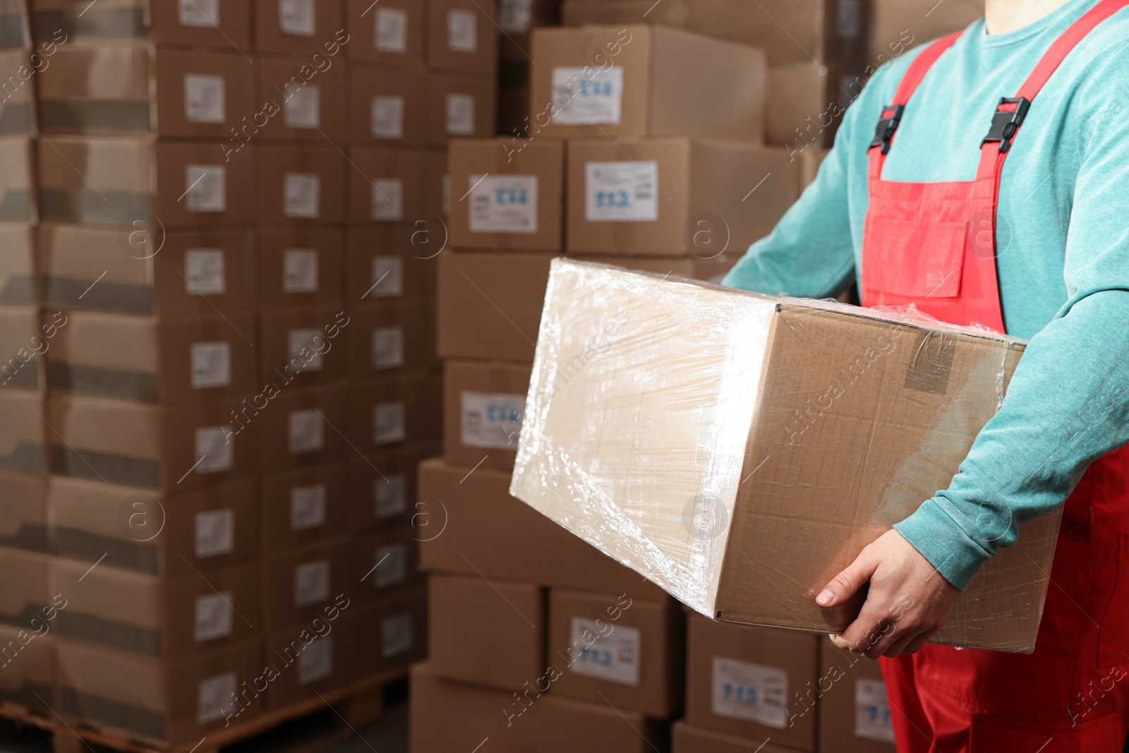 Photo of Worker with cardboard box in warehouse, closeup. Wholesaling