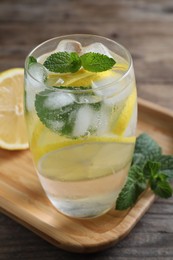 Photo of Delicious lemonade made with soda water and fresh ingredients on wooden table, closeup