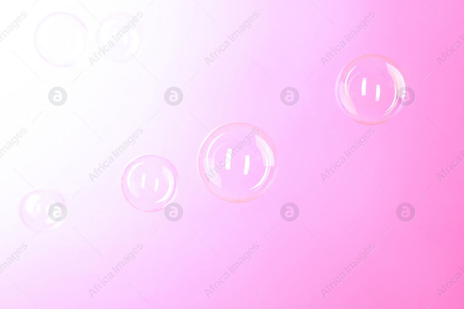 Photo of Beautiful transparent soap bubbles on color background