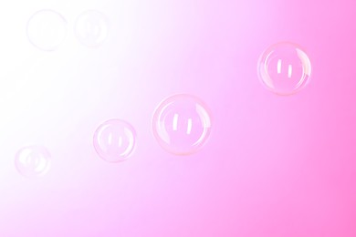Photo of Beautiful transparent soap bubbles on color background