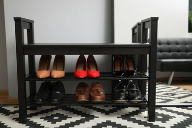 Photo of Shelving unit with stylish shoes near grey wall in hallway