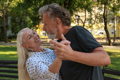 Photo of Lovely mature couple dancing together in park