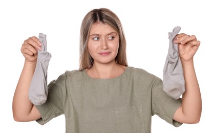 Young woman feeling bad smell from dirty socks isolated on white