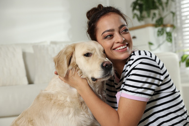 Young woman and her Golden Retriever at home. Adorable pet