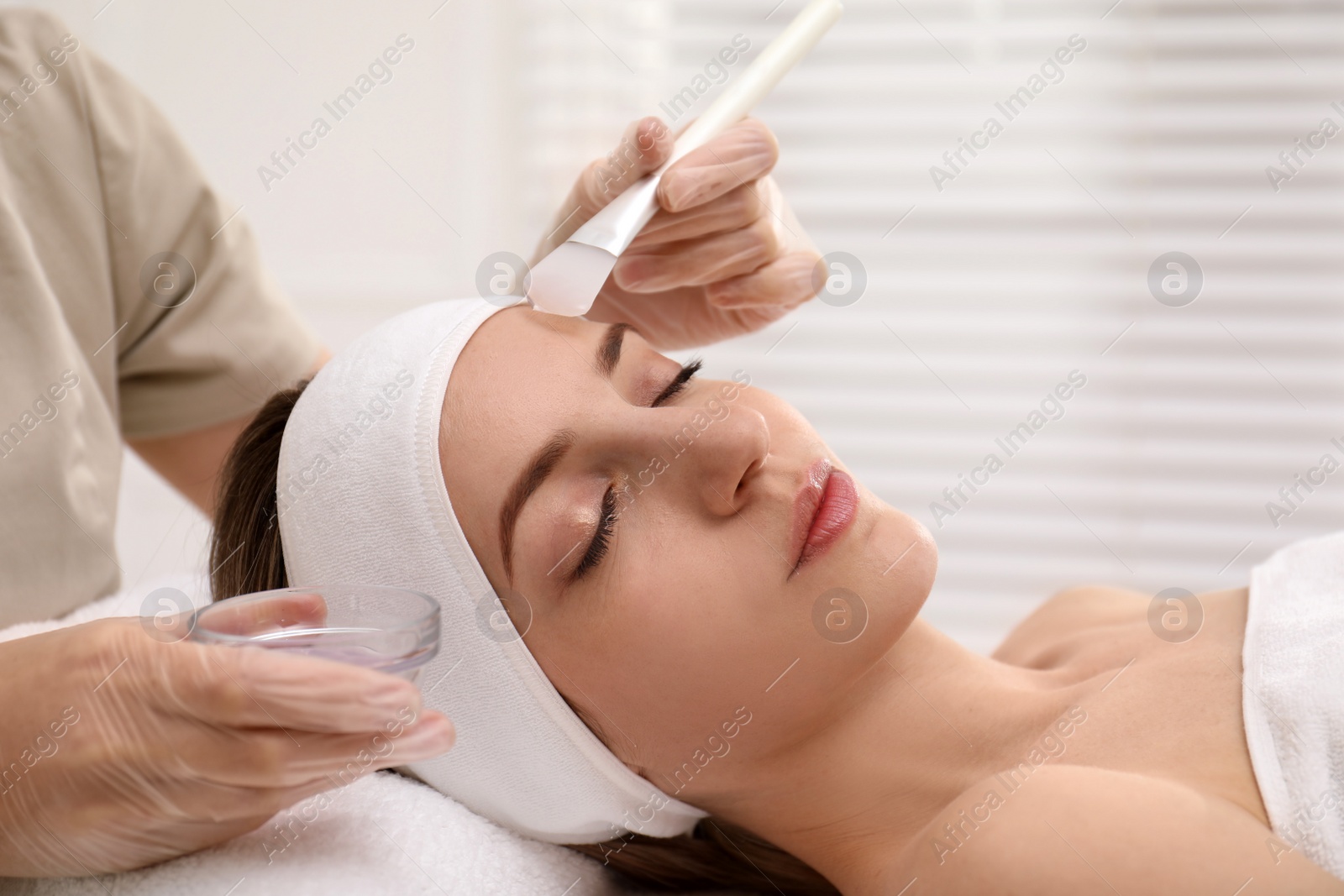 Photo of Young woman during face peeling procedure in salon