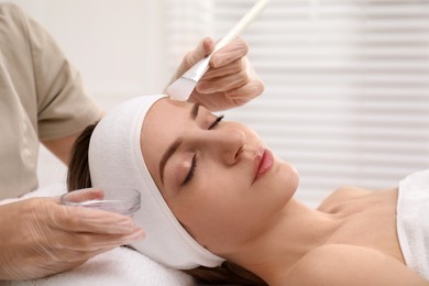 Young woman during face peeling procedure in salon