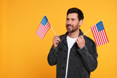 Photo of 4th of July - Independence Day of USA. Happy man with American flags on yellow background, space for text