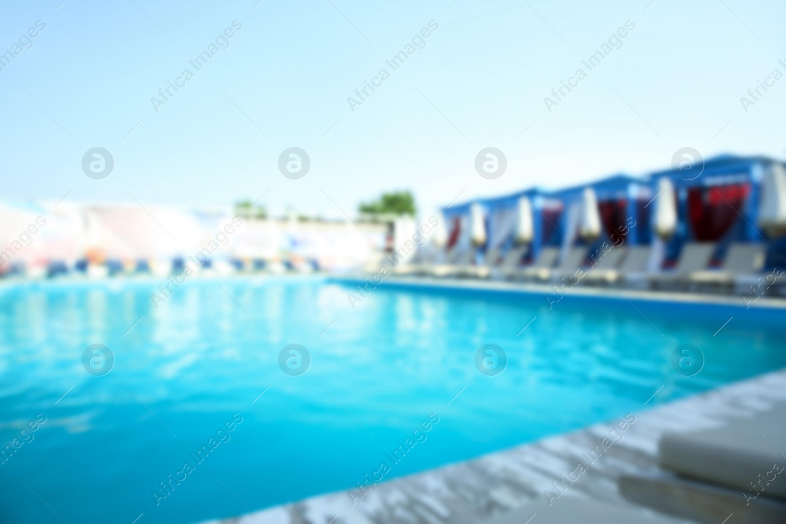 Photo of Blurred view of modern outdoor swimming pool on sunny day