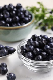 Photo of Ripe bilberries on white marble table, closeup