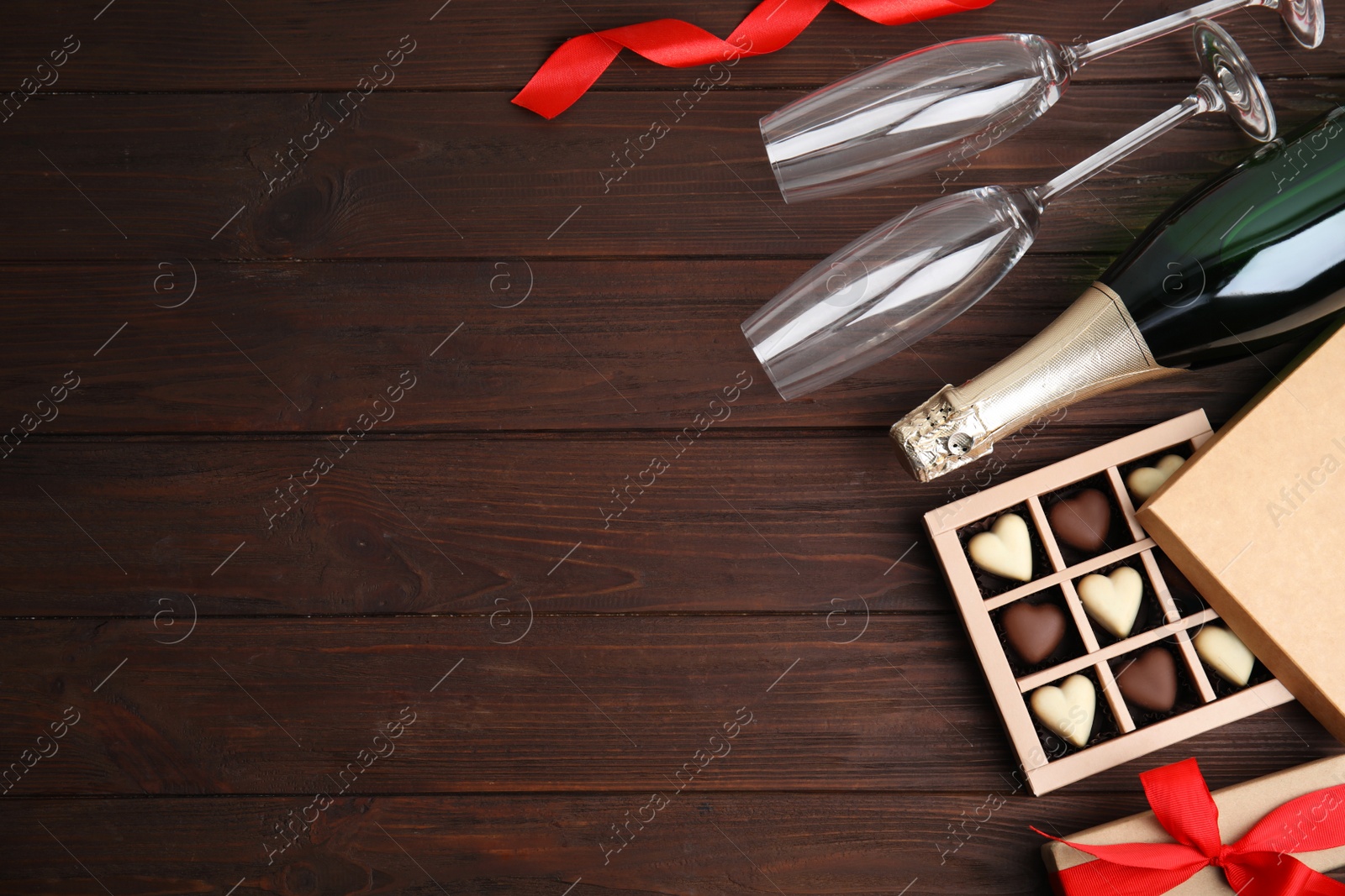 Photo of Flat lay composition with heart shaped chocolate candies on wooden table, space for text. Happy Valentine's day