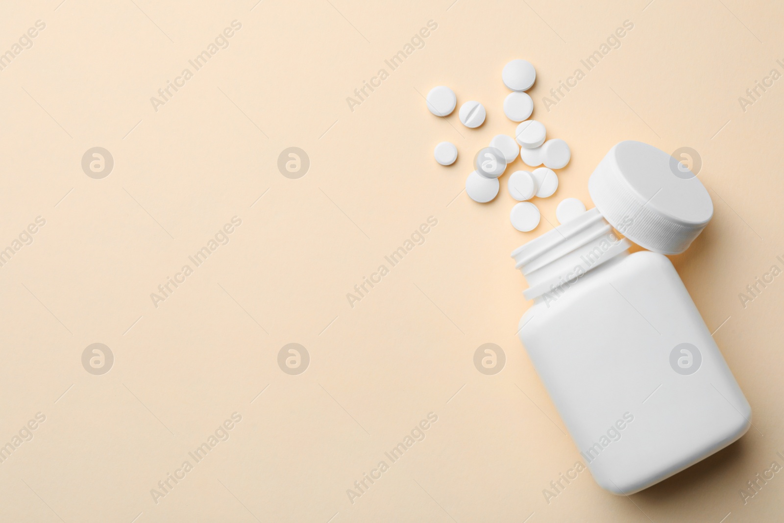 Photo of Bottle with different pills on color background, flat lay. Space for text