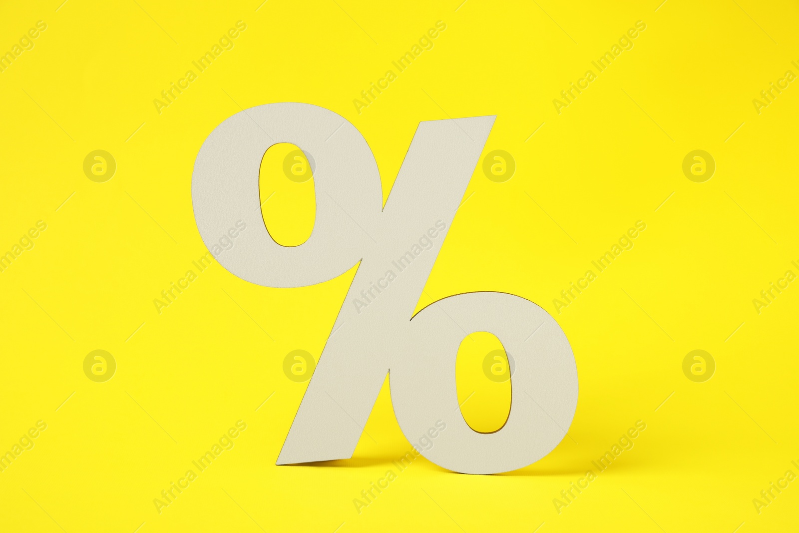 Photo of White wooden percent sign on yellow background