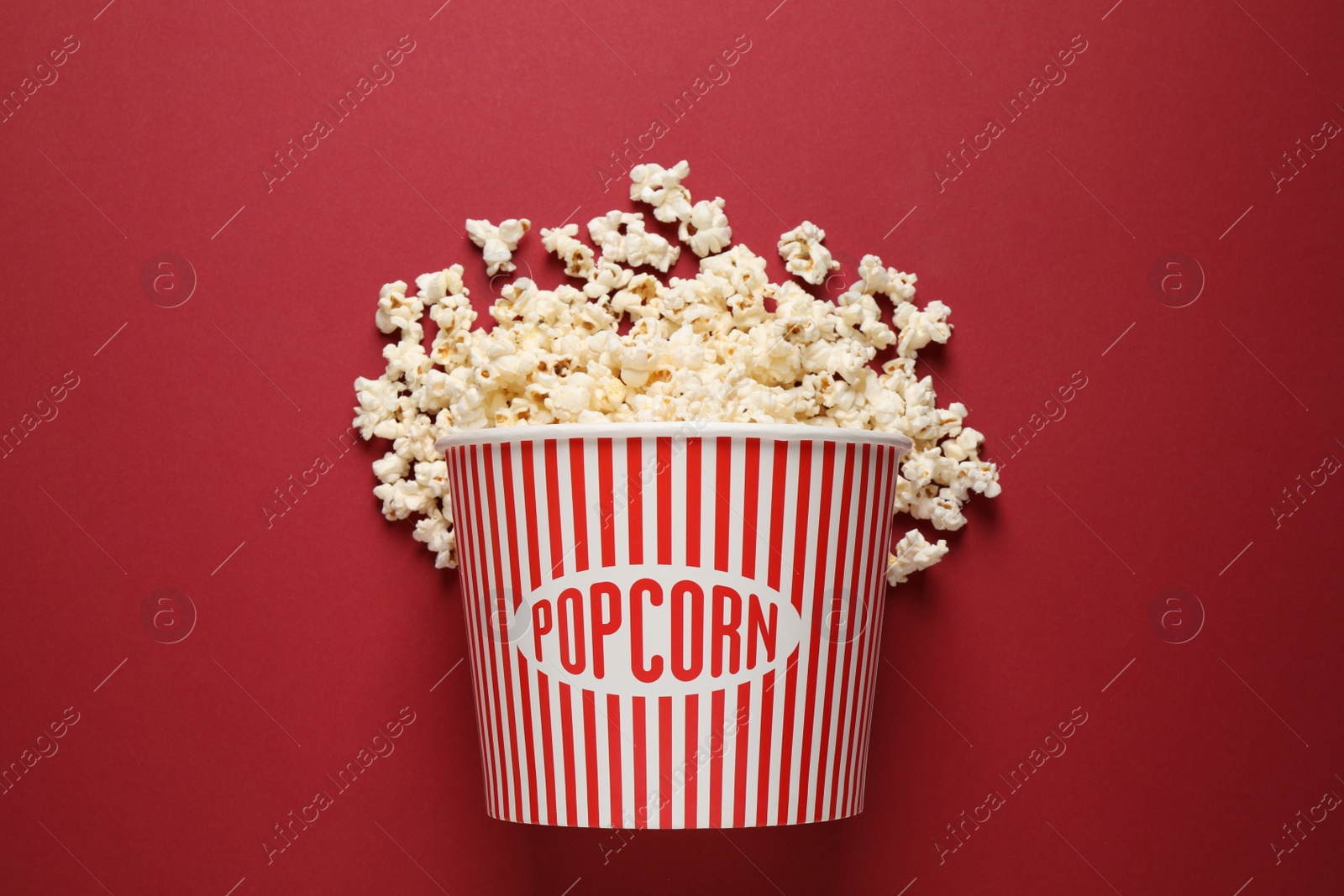 Photo of Delicious popcorn on red background, top view