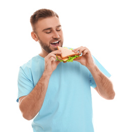 Photo of Young man eating tasty sandwich on white background