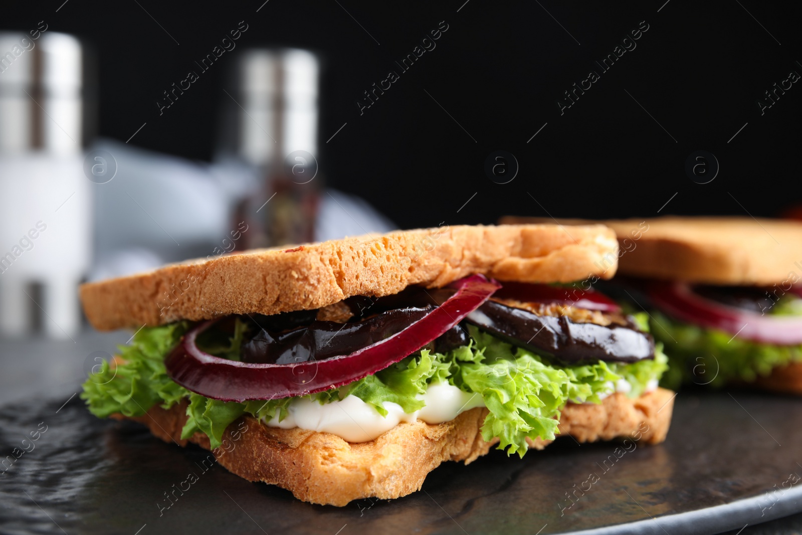 Photo of Delicious eggplant sandwiches on slate board, closeup