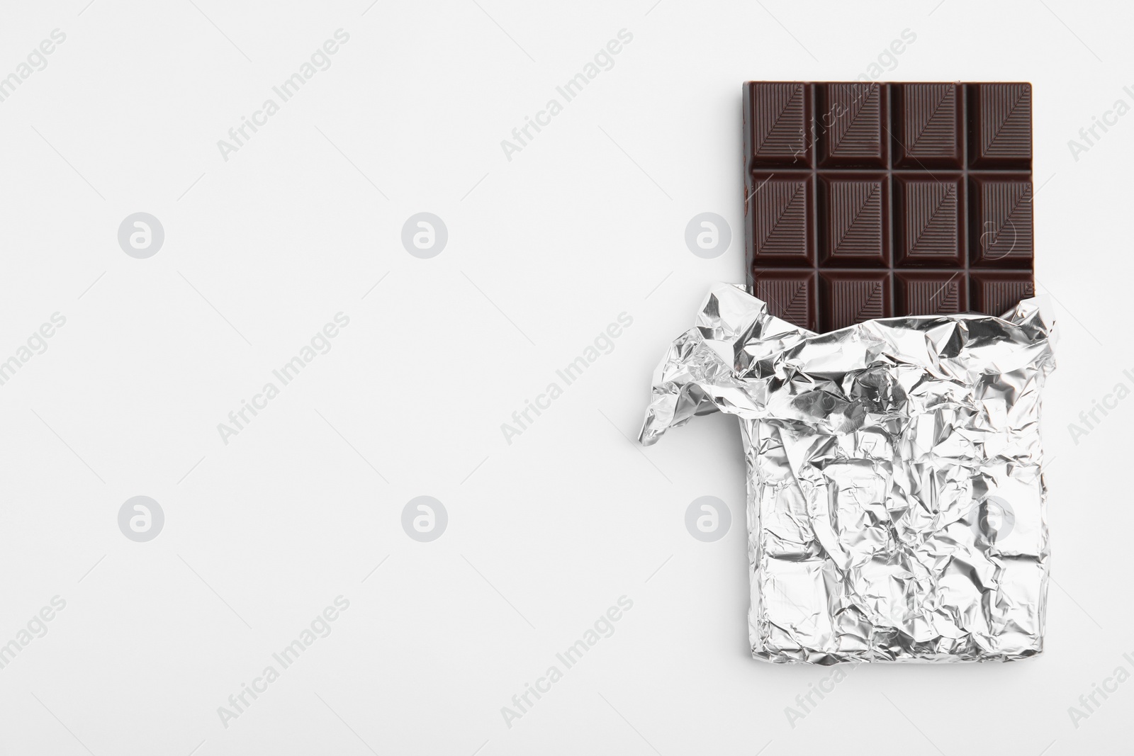 Photo of Tasty chocolate bar on white background, top view
