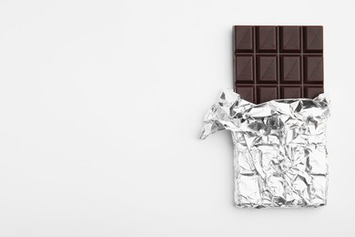 Tasty chocolate bar on white background, top view