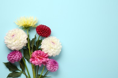 Photo of Beautiful dahlia flowers on light blue background, flat lay. Space for text