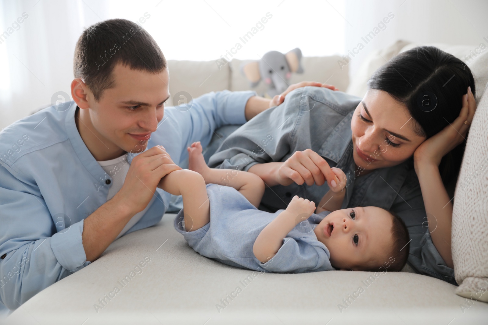 Photo of Happy family with cute baby on sofa at home