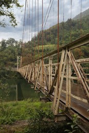 Photo of Beautiful view on rusty metal bridge over river in mountains