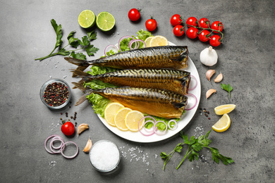 Flat lay composition with tasty smoked fish on grey table