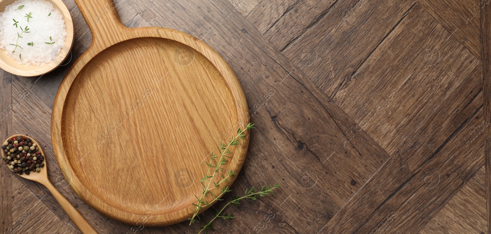 Photo of Cutting board and different spices on wooden table, flat lay. Space for text