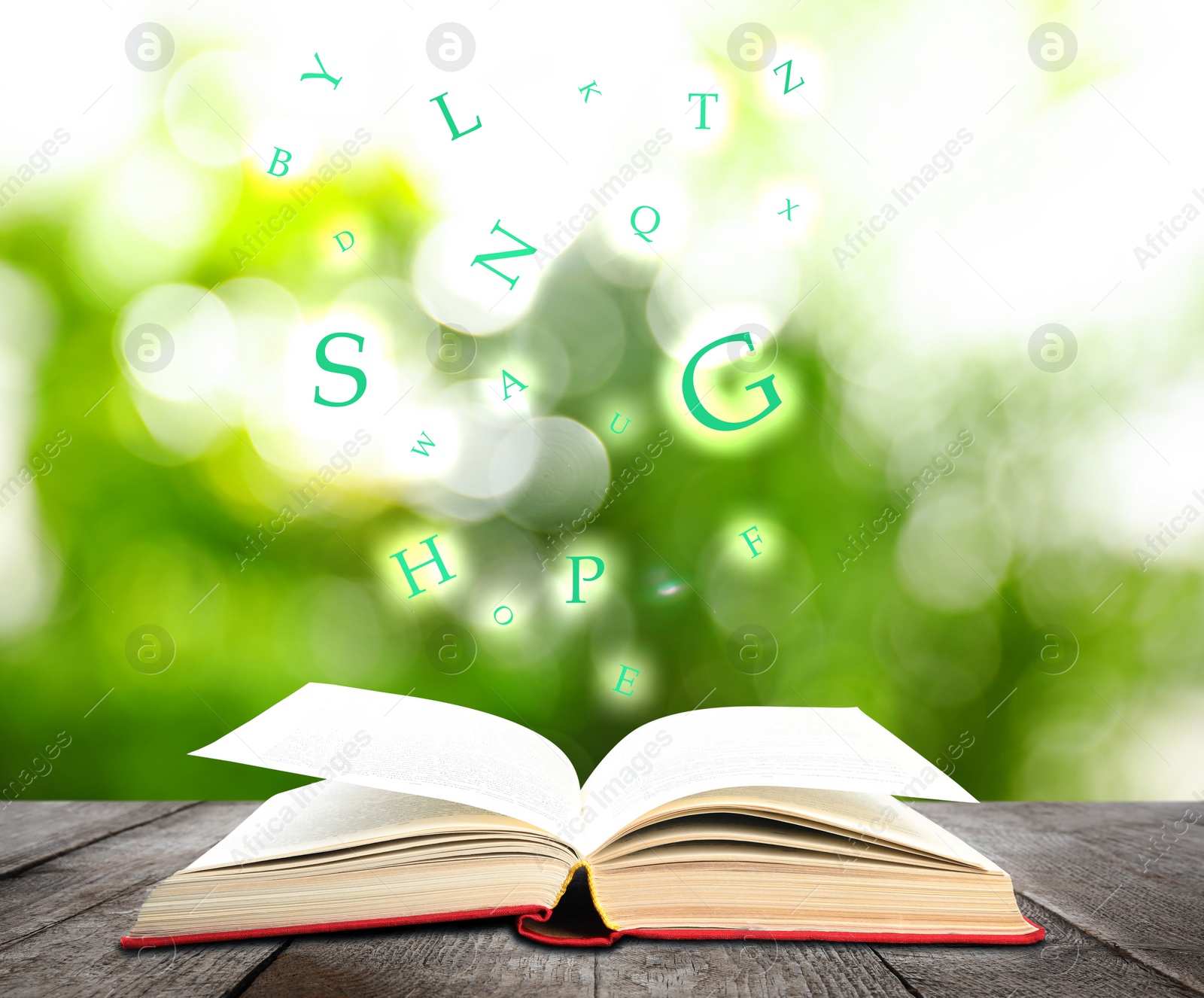 Image of Open book with letters flying out of it on wooden table against blurred background