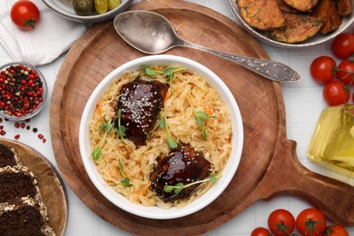 Photo of Bowl with sauerkraut and chicken served on white table, flat lay