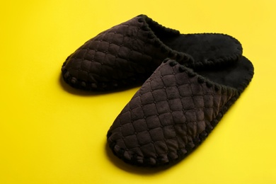 Pair of soft slippers on yellow background