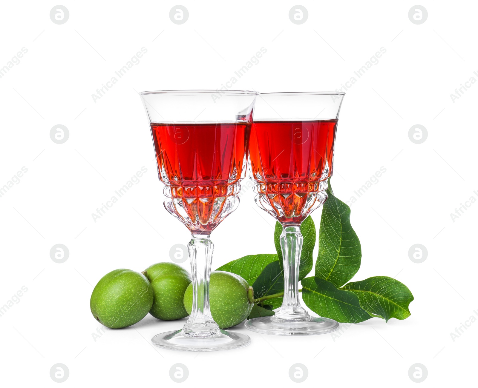 Photo of Delicious liqueur and green walnuts on white background