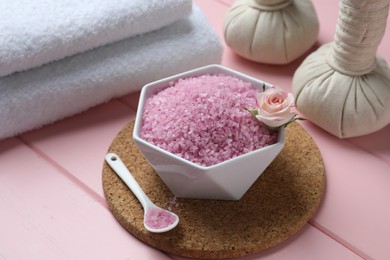 Composition with sea salt and herbal bags on pink wooden table, closeup