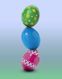 Image of Stack of bright Easter eggs on blue green gradient background