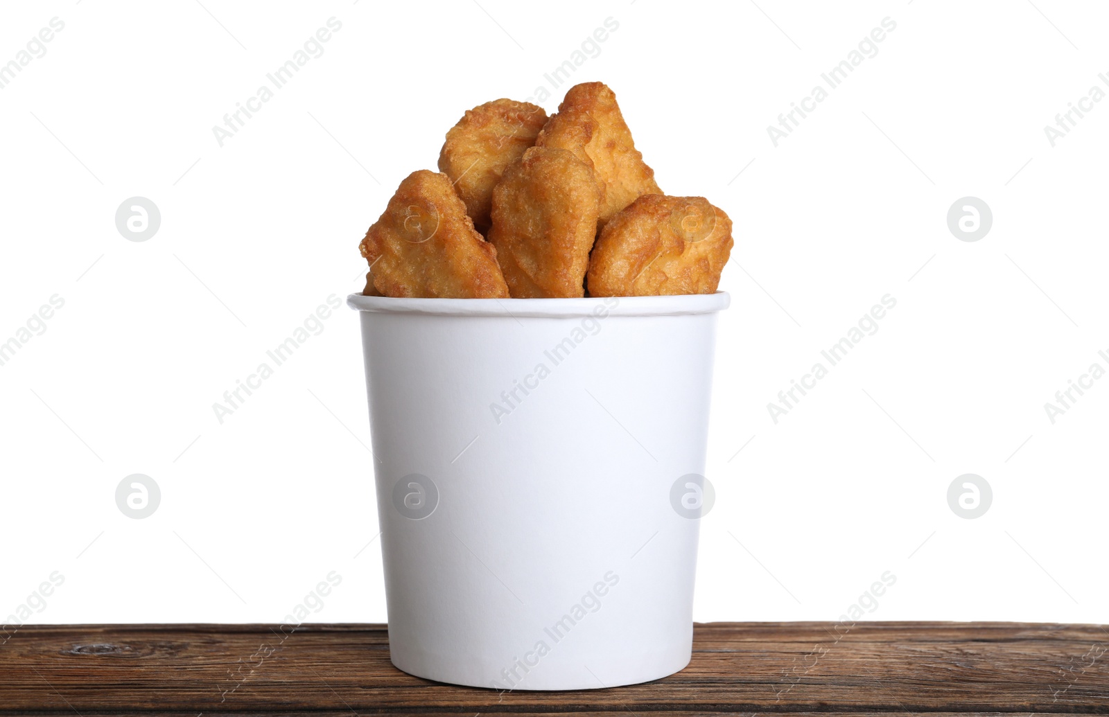 Photo of Bucket with tasty chicken nuggets on wooden table against white background