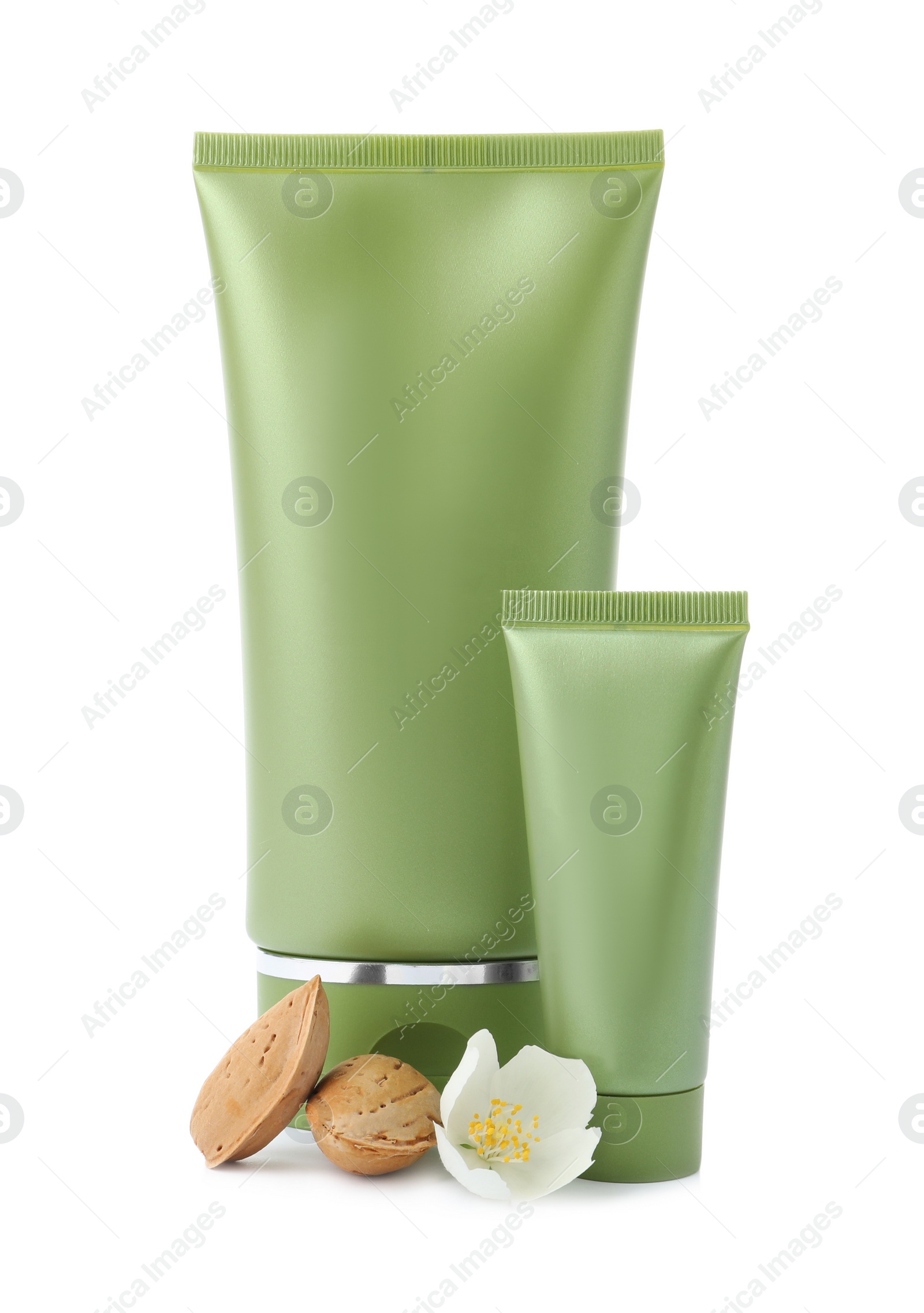 Photo of Tubes of cosmetic products, almond nuts and flower isolated on white