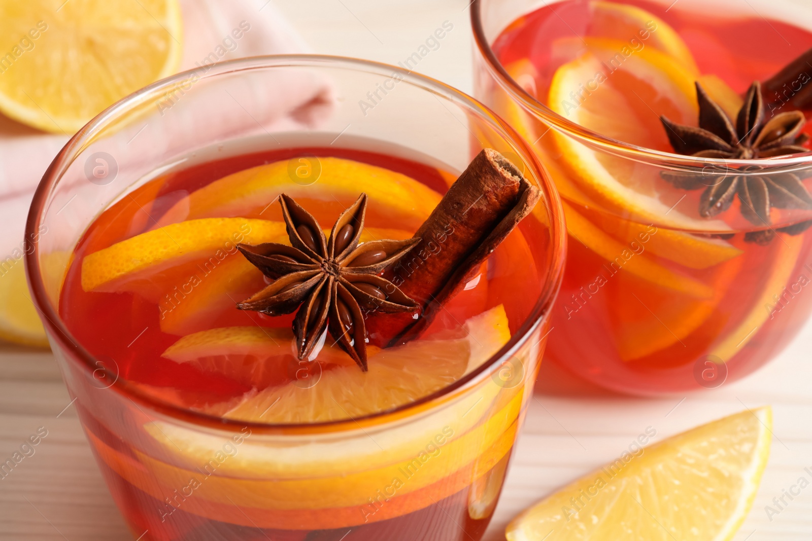 Photo of Aromatic punch drink on white wooden table, closeup