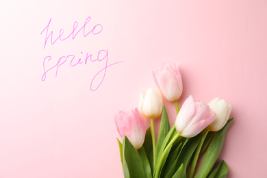 Photo of Words HELLO SPRING and fresh tulip flowers on pink background, flat lay