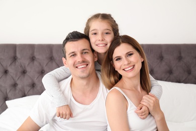 Photo of Happy family with cute child in bedroom
