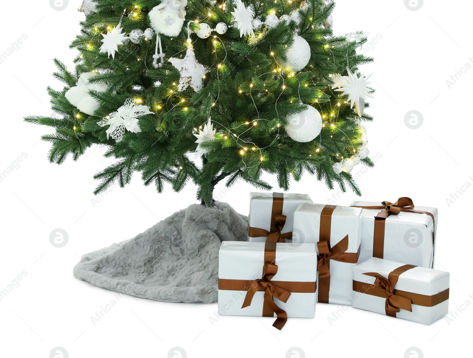 Photo of Decorated Christmas tree with faux fur skirt and gifts on white background