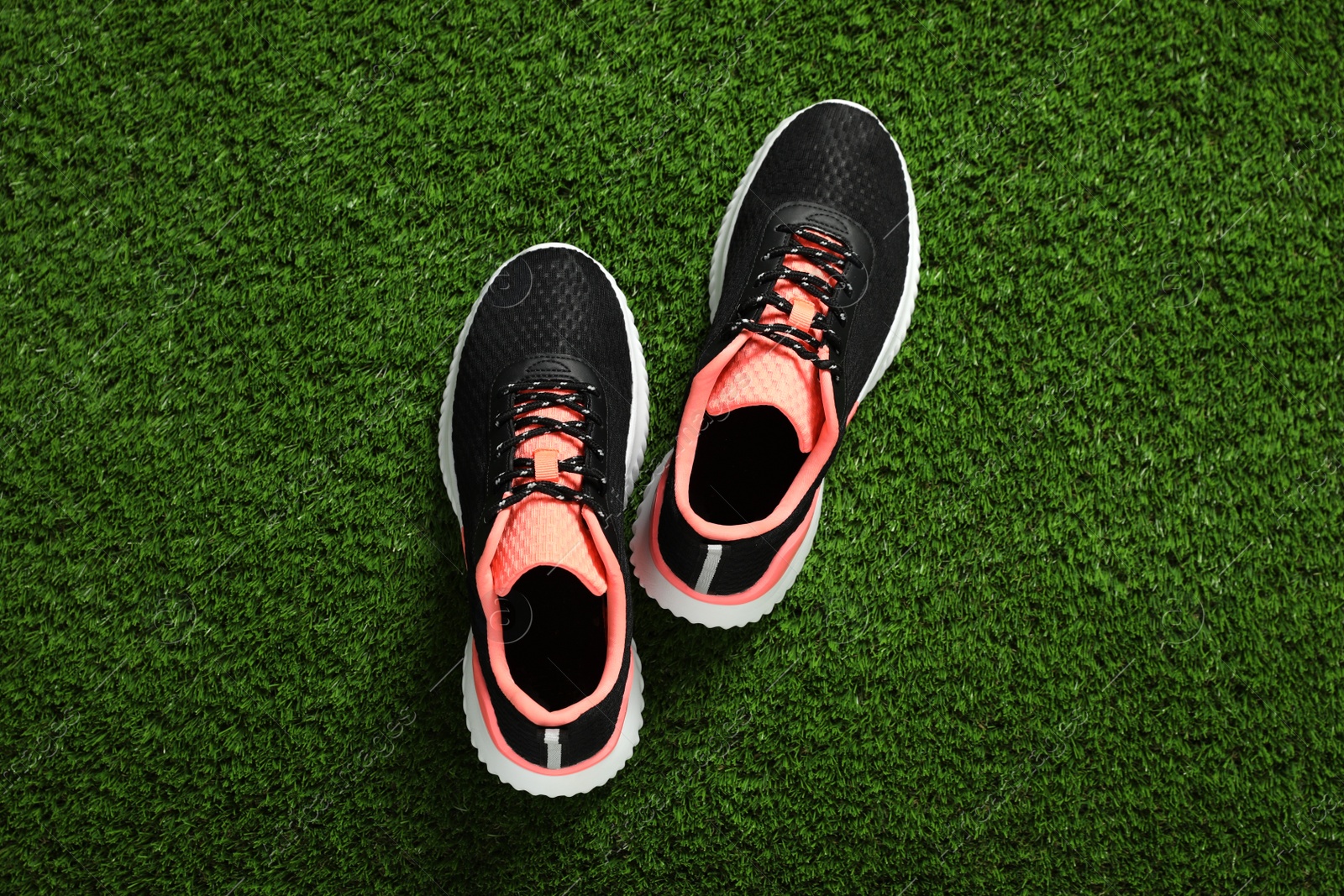 Photo of Pair of stylish sport shoes on green grass, flat lay