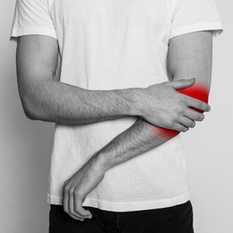 Image of Man suffering from rheumatism, closeup. Black and white effect with red accent in painful area