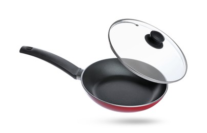 Image of New frying pan and glass lid on white background