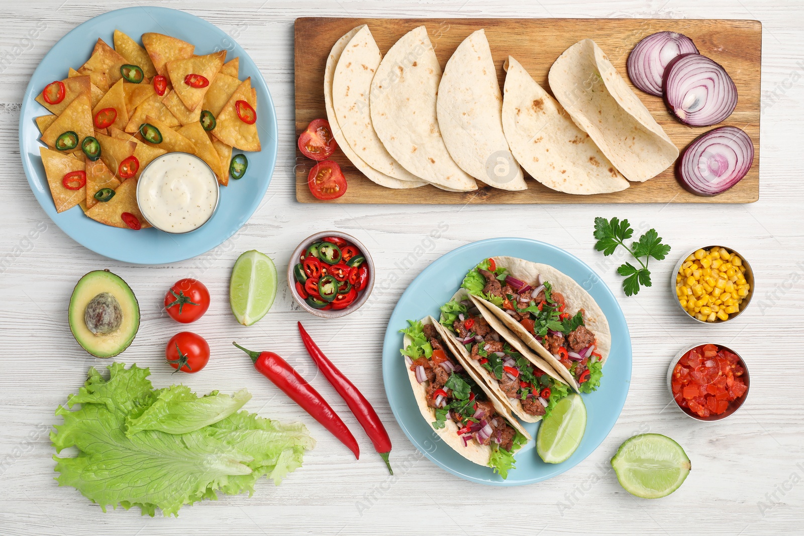 Photo of Flat lay composition with delicious tacos on wooden table