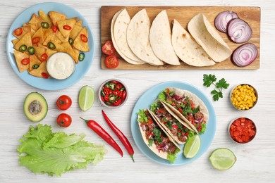 Photo of Flat lay composition with delicious tacos on wooden table