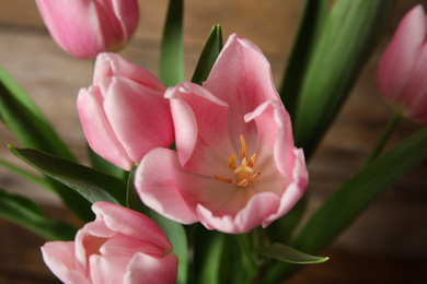 Photo of Beautiful pink spring tulips on wooden background, closeup