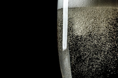 Photo of Glass of champagne on black background, closeup. Space for text