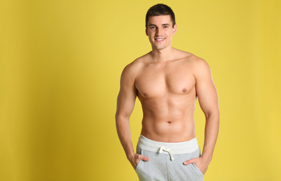 Photo of Man with sexy body on yellow background. Space for text