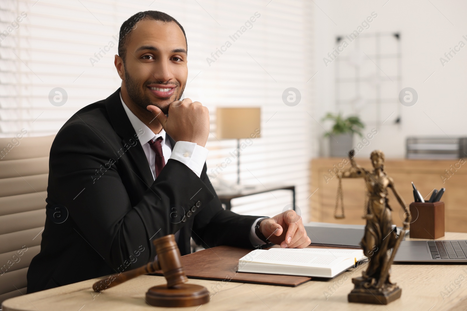 Photo of Portrait of smiling lawyer at table in office