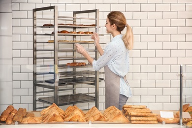 Beautiful woman at showcase in bakery shop