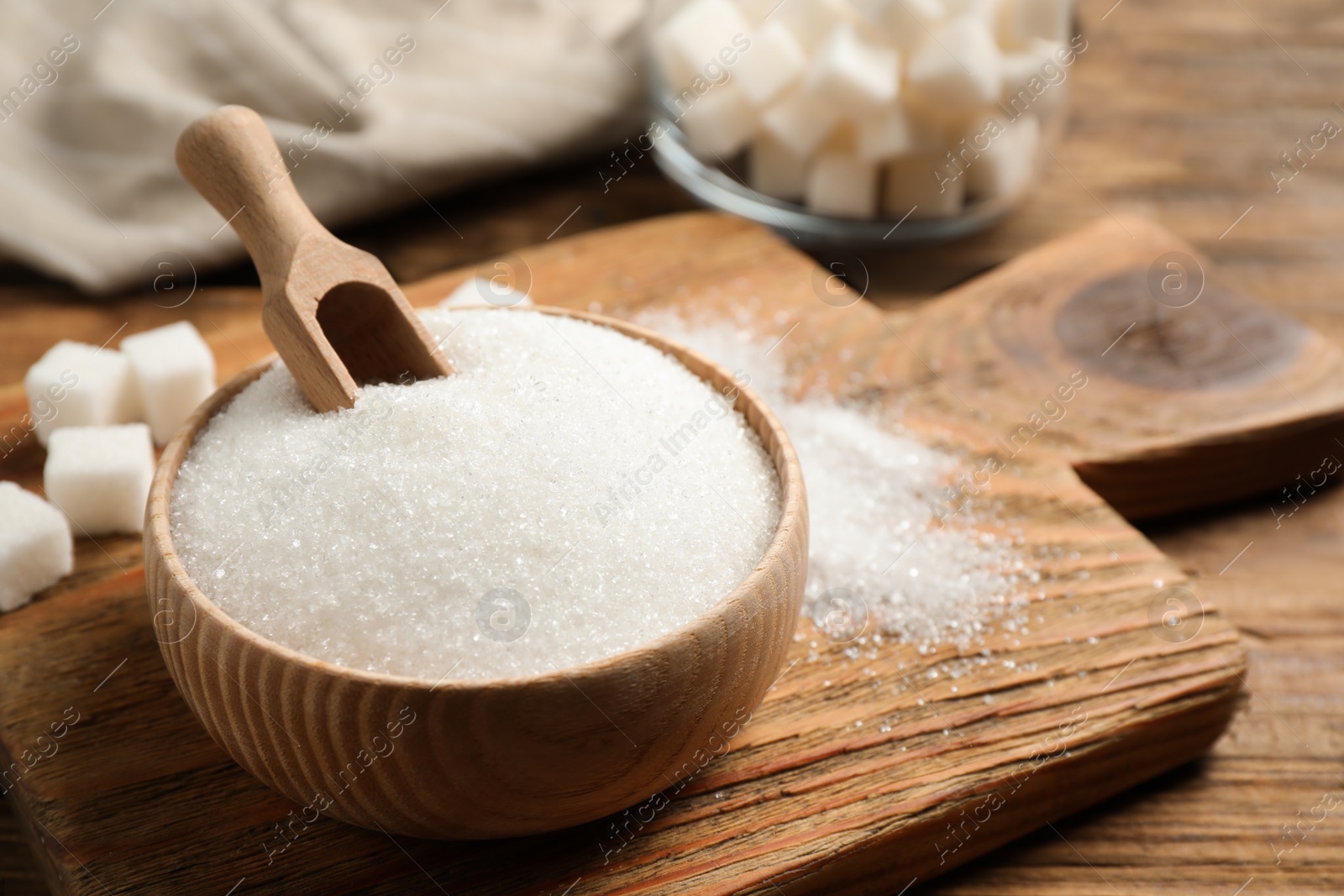 Photo of Granulated sugar in bowl on wooden table