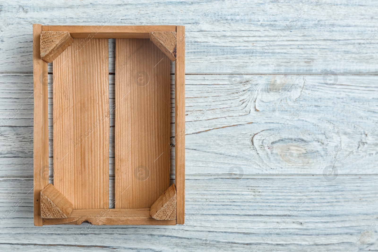 Photo of Empty crate on wooden background, top view with space for text